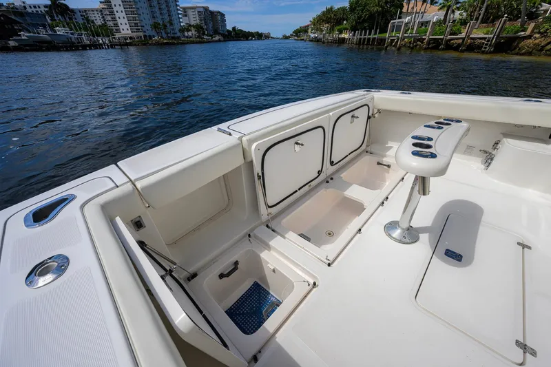 Slide: The Image of 2004 Pursuit 3800 Express boat deck with storage compartments and rod holders. - 54