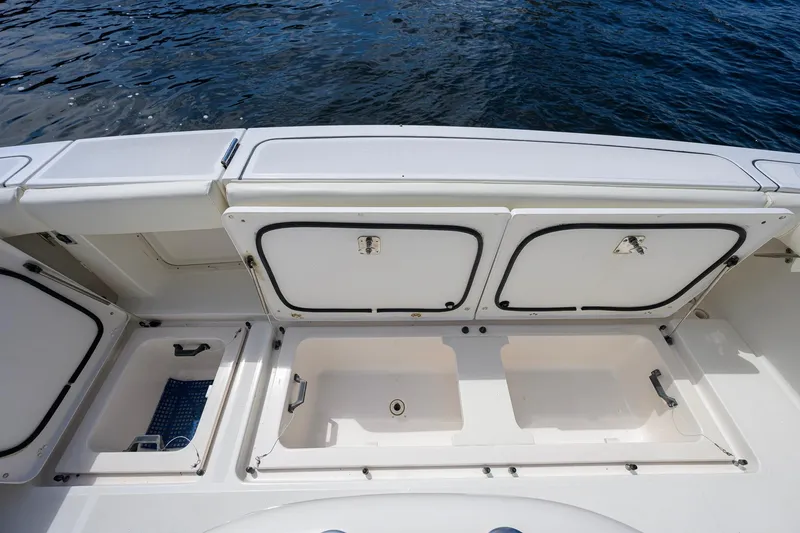 Slide: The Image of Open storage compartments on a 2004 Pursuit 3800 Express boat deck. - 56