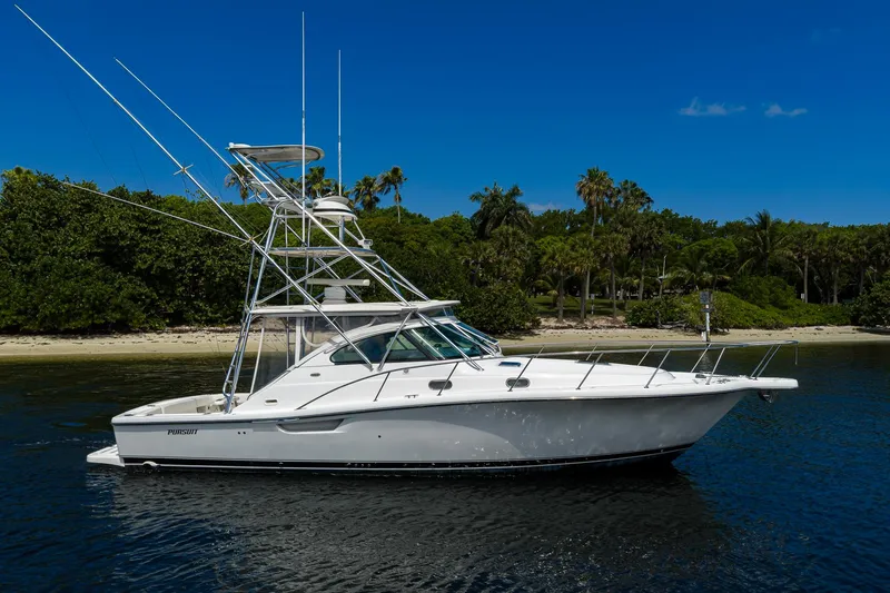 Slide: The Image of 2004 Pursuit 3800 Express yacht anchored near tropical shoreline under clear blue sky. - 6