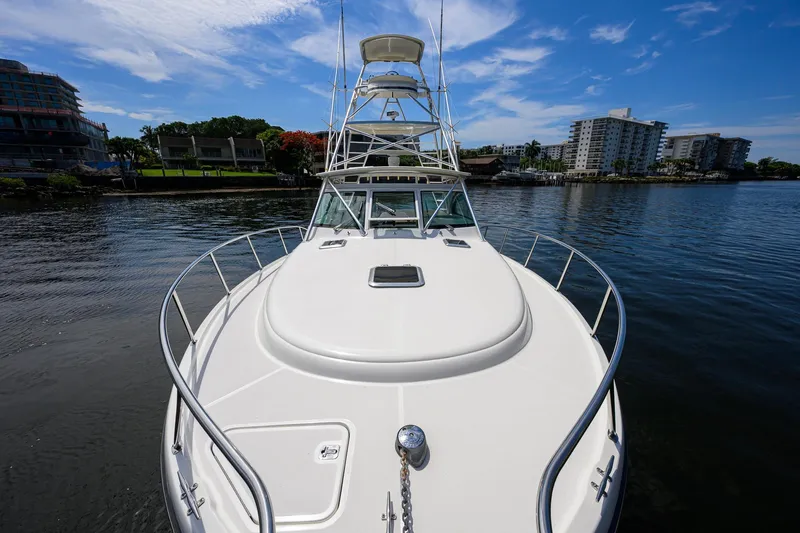 Slide: The Image of 2004 Pursuit 3800 Express boat on calm water with cityscape background. - 61