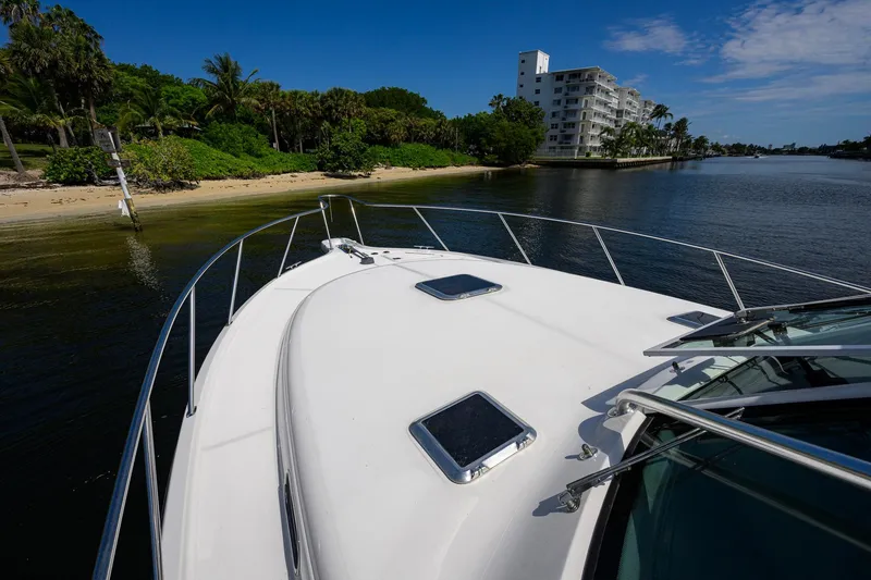 Slide: The Image of 2004 Pursuit 3800 Express yacht cruising near a tropical shoreline with palm trees. - 65