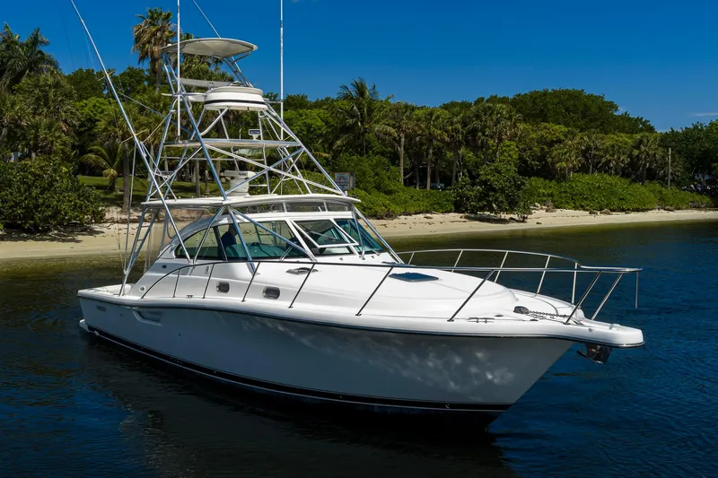 Slide: The Image of 2004 Pursuit 3800 Express yacht on calm water near a tropical shoreline. - 7