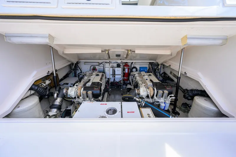 Slide: The Image of Engine compartment of a 2004 Pursuit 3800 Express boat, showcasing dual engines and equipment. - 73