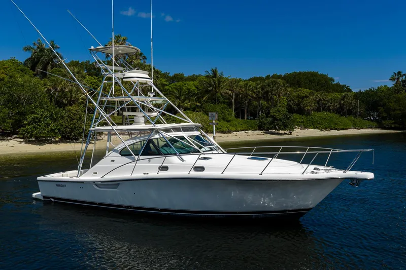 Slide: The Image of 2004 Pursuit 3800 Express yacht on calm water near a tropical shoreline. - 8