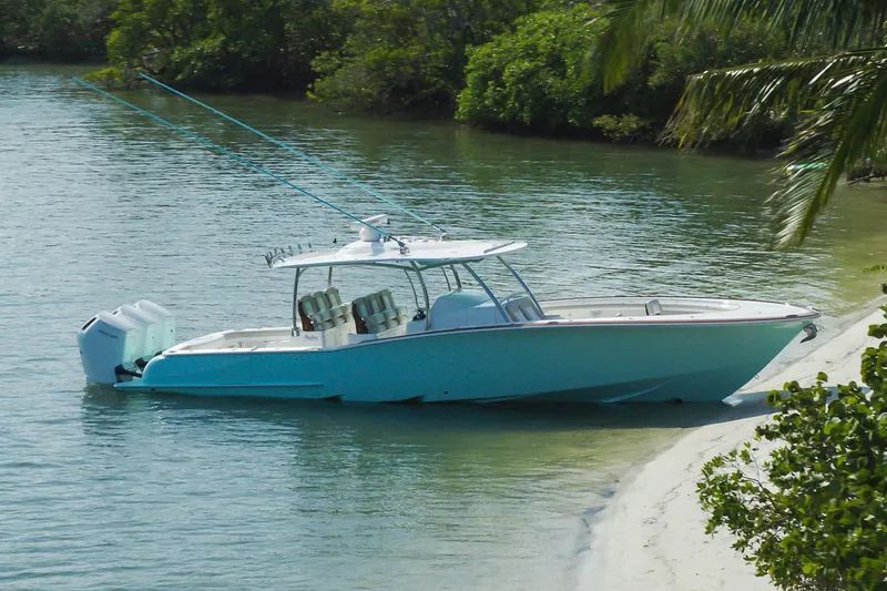 Slide: The Image of Manufacturer Provided Image: 2025 Mag Bay 43 CC boat docked on a sandy shore with lush greenery. - 6