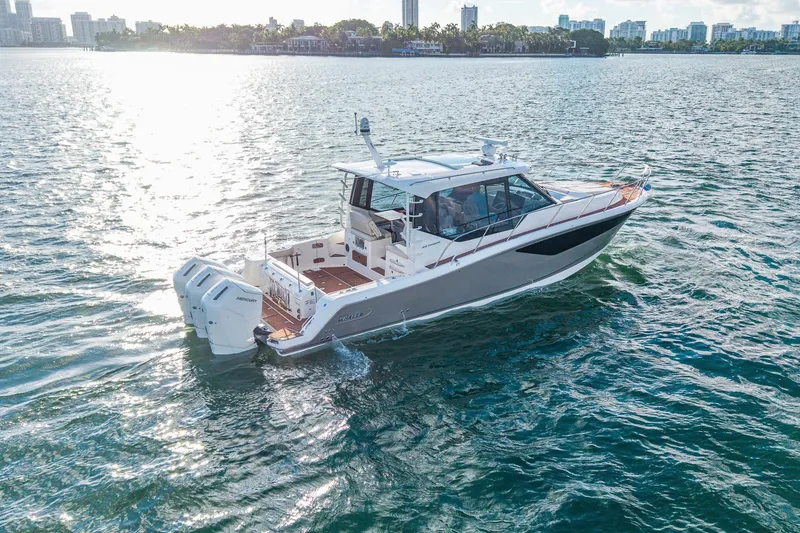 Slide: The Image of 2024 Boston Whaler 405 Conquest cruising on a sunny day, city skyline in background. - 1