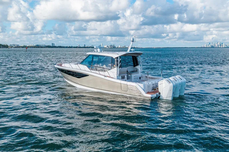 Slide: The Image of 2024 Boston Whaler 405 Conquest boat cruising on open water under a cloudy sky. - 2