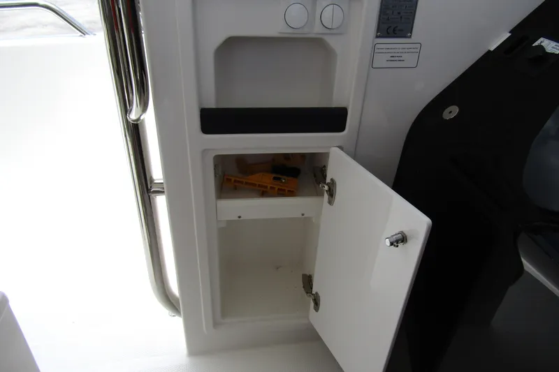 Slide: The Image of Open storage compartment on 2025 Nimbus Tender 11 boat interior. - 21