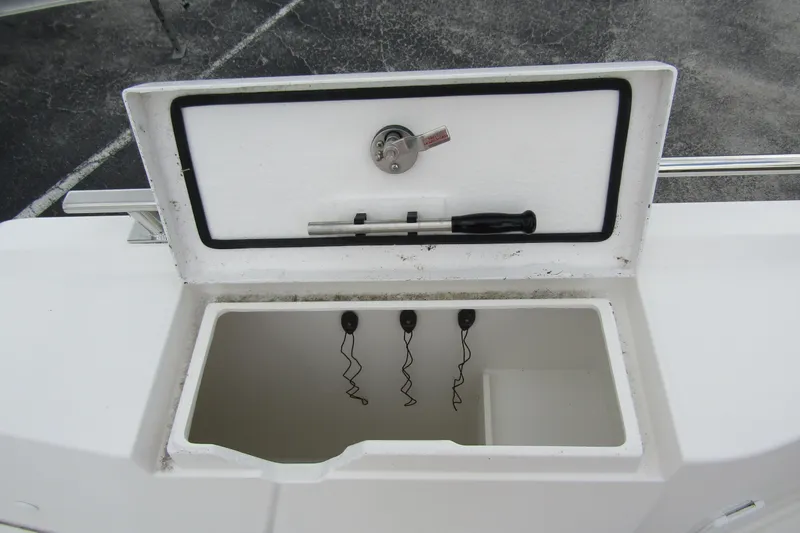 Slide: The Image of Open storage compartment on 2025 Nimbus Tender 11 boat, featuring a lock and tools. - 44
