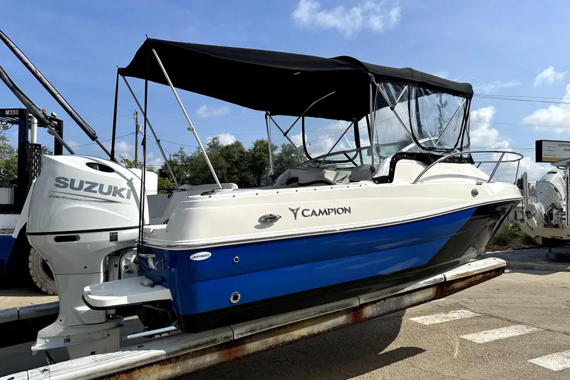 Slide: The Image of 2021 Campion A21 boat with Suzuki engine, blue and white design, docked under a clear sky. - 3