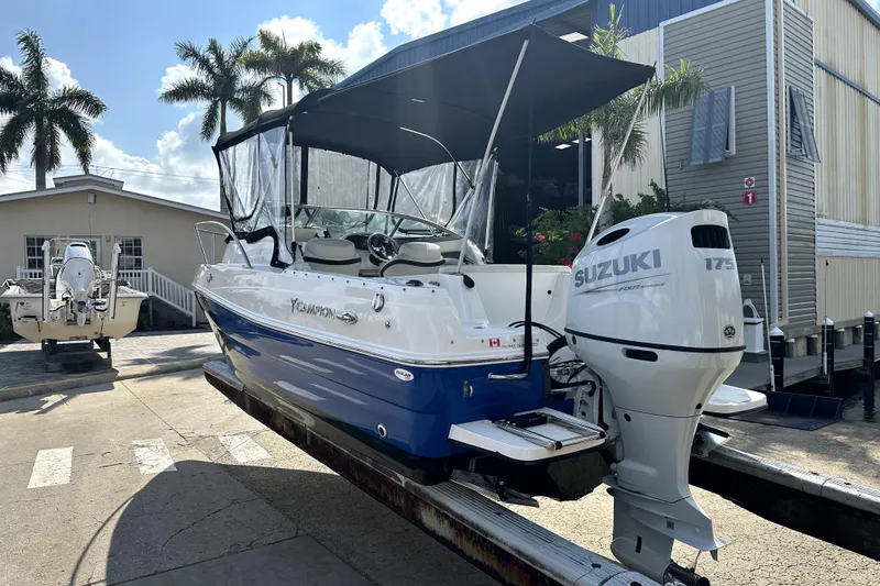 Slide: The Image of 2021 Campion A21 boat with Suzuki 175 engine on trailer, surrounded by palm trees. - 4