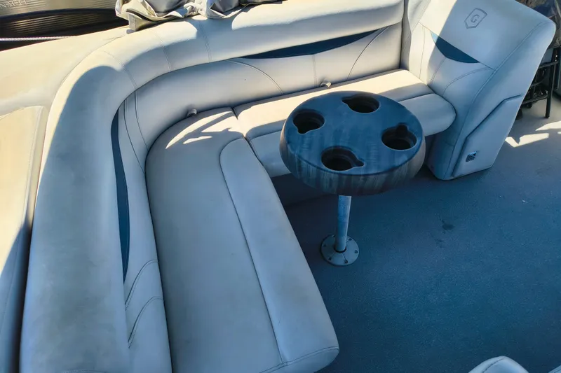 Slide: The Image of 2018 Godfrey Sweetwater 2286 C boat interior with cushioned seating and cup holder table. - 4