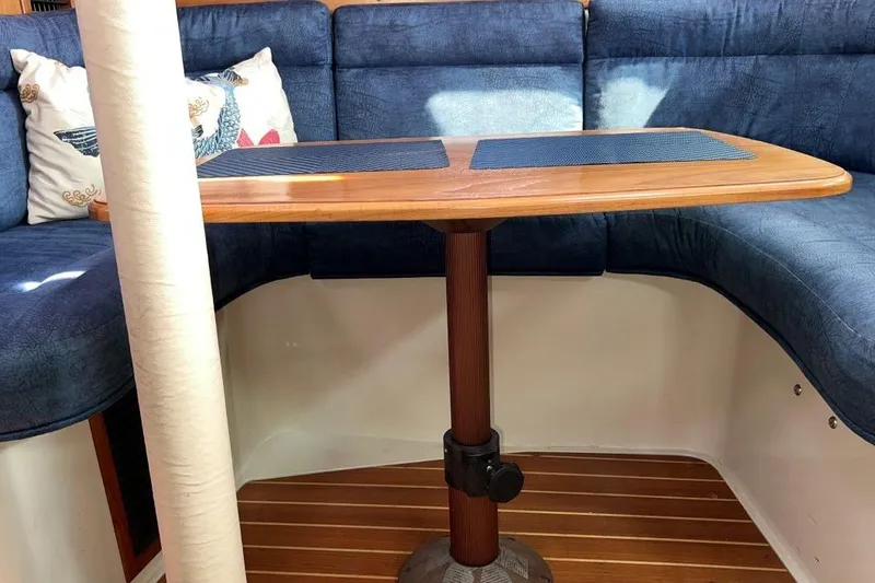 Slide: The Image of Interior of a 2001 Catalina 34 MkII sailboat with a wooden table and blue seating. - 18