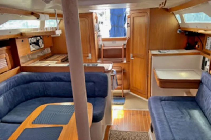 Slide: The Image of Interior of a 2001 Catalina 34 MkII sailboat with blue seating and wooden finishes. - 17