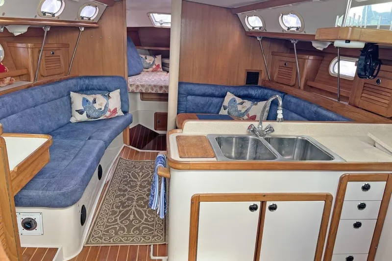 Slide: The Image of Interior of a 2001 Catalina 34 MkII sailboat with blue seating and a compact kitchen. - 15