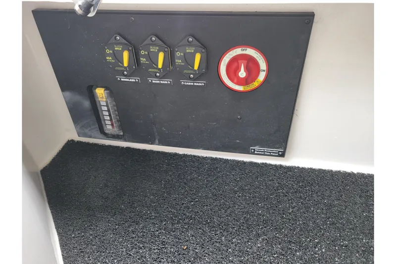 Slide: The Image of Control panel of a 2023 Regal 26 XO boat with switches and a red dial. - 11