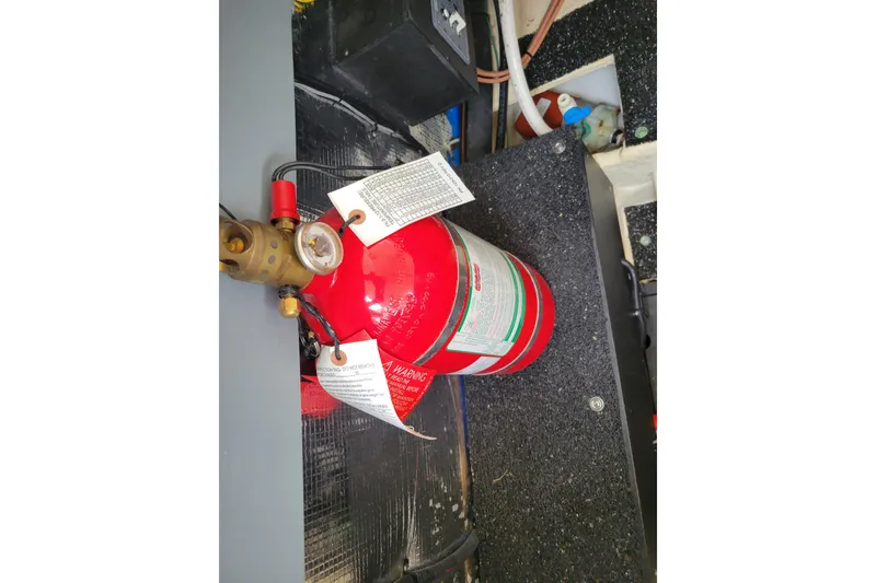 Slide: The Image of Red fire extinguisher in a 2023 Regal 26 XO boat interior. - 12