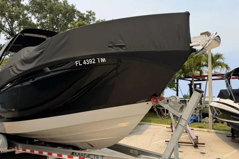 Slide: The Image of 2023 Regal 26 XO boat on trailer, covered, with visible registration number. - 21