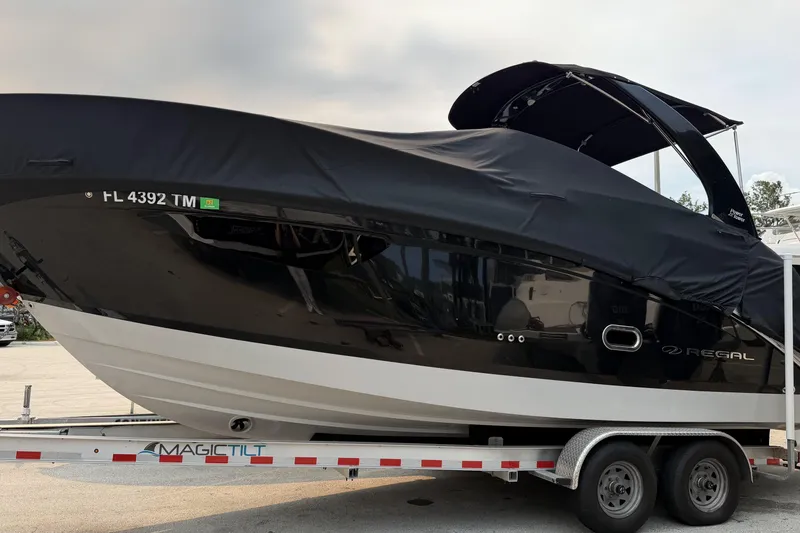 Slide: The Image of 2023 Regal 26 XO boat on trailer, covered, with Magic Tilt branding. - 22