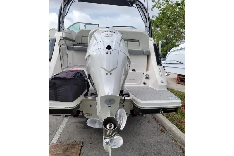 Slide: The Image of 2023 Regal 26 XO boat with powerful outboard motor, docked on a concrete surface. - 23