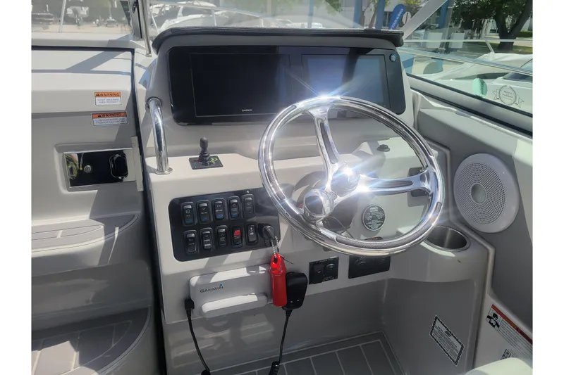 Slide: The Image of 2023 Regal 26 XO boat helm with steering wheel and control panel. - 3