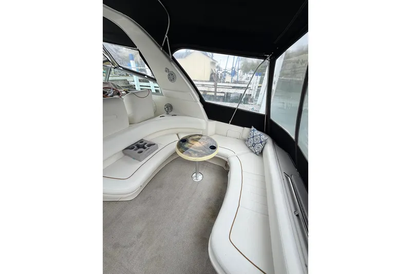 Slide: The Image of 1999 Sea Ray Sundancer 310 interior with white seating, table, and decorative pillows. - 10