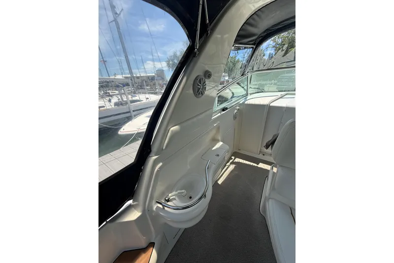 Slide: The Image of Interior view of 1999 Sea Ray Sundancer 310 yacht with seating and marina backdrop. - 12