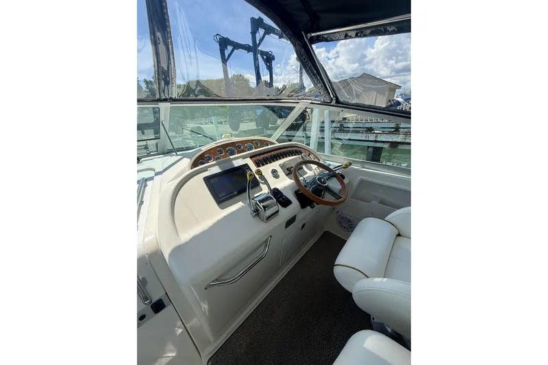 Slide: The Image of Cockpit of 1999 Sea Ray Sundancer 310 with steering wheel and navigation controls. - 15