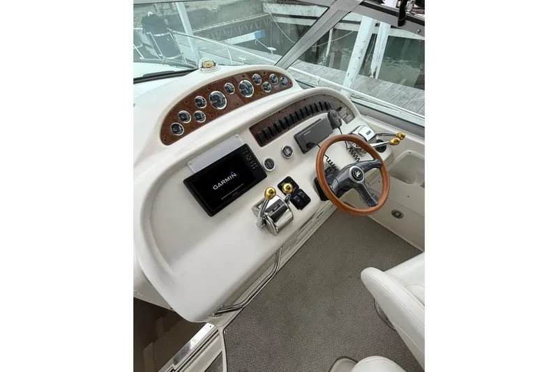 Slide: The Image of 1999 Sea Ray Sundancer 310 helm with Garmin navigation and wood-accented steering wheel. - 16
