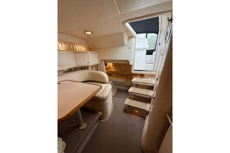 Slide: The Image of Interior of 1999 Sea Ray Sundancer 310 yacht, featuring cozy seating and elegant design. - 22