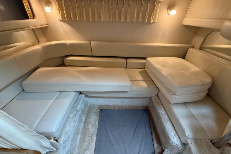 Slide: The Image of 1999 Sea Ray Sundancer 310 cabin interior with beige seating and soft lighting. - 24