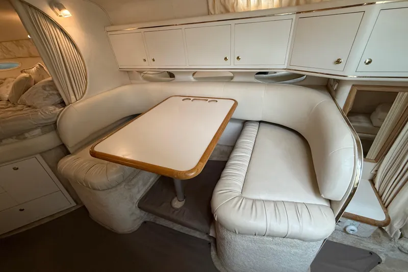 Slide: The Image of 1999 Sea Ray Sundancer 310 interior with white leather seating and dining table. - 25
