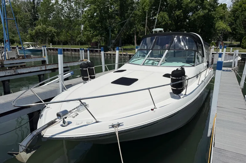 Slide: The Image of 1999 Sea Ray Sundancer 310 docked at marina, surrounded by lush greenery. - 3