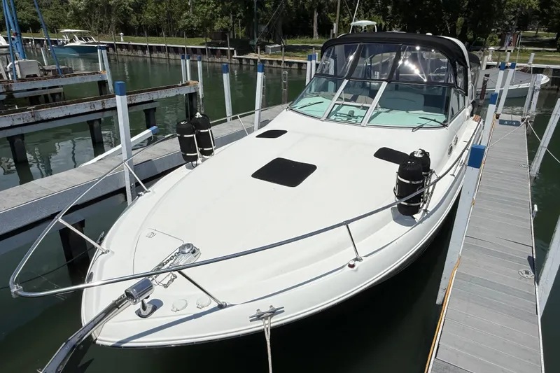 Slide: The Image of 1999 Sea Ray Sundancer 310 docked at marina, featuring sleek design and spacious deck. - 4