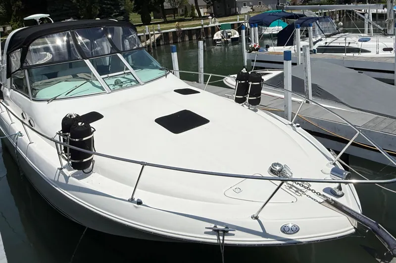 Slide: The Image of 1999 Sea Ray Sundancer 310 docked at marina, featuring sleek white design. - 5