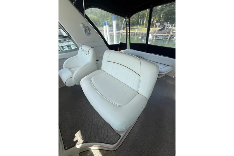 Slide: The Image of Interior seating of a 1999 Sea Ray Sundancer 310 boat, featuring white upholstery. - 9