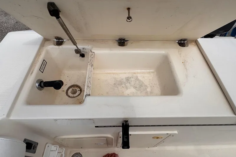 Slide: The Image of Open storage compartment on a 2004 Pursuit 2670 Cuddy Console boat. - 11