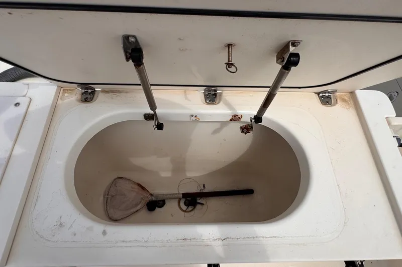 Slide: The Image of Open storage compartment on 2004 Pursuit 2670 Cuddy Console boat, showing interior details. - 12