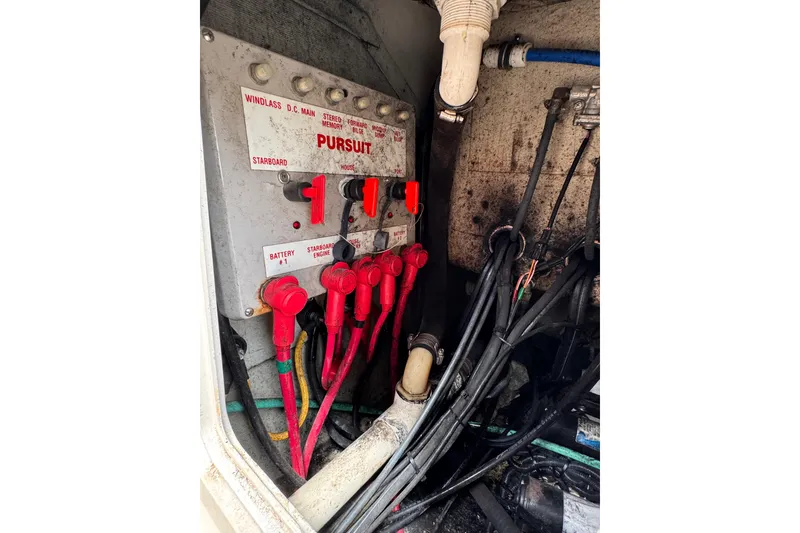 Slide: The Image of Electrical panel of a 2004 Pursuit 2670 Cuddy Console boat with labeled switches and cables. - 14