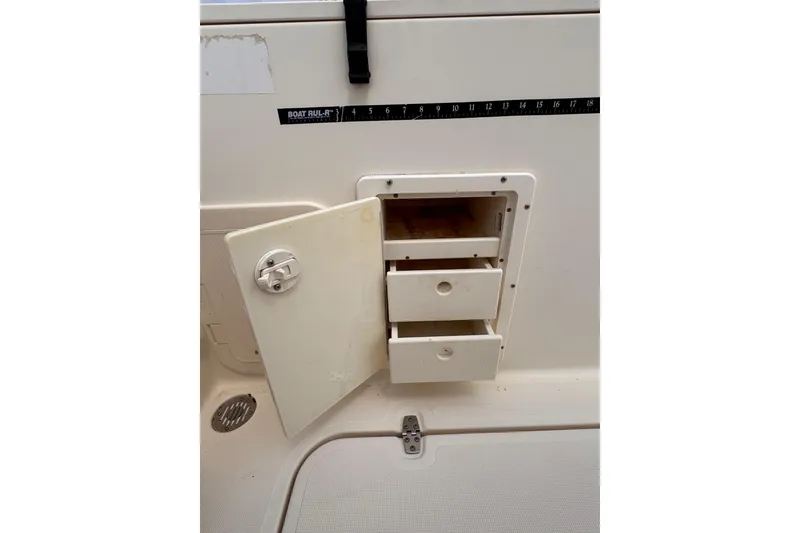 Slide: The Image of Open storage compartment with drawers on a 2004 Pursuit 2670 Cuddy Console boat. - 15