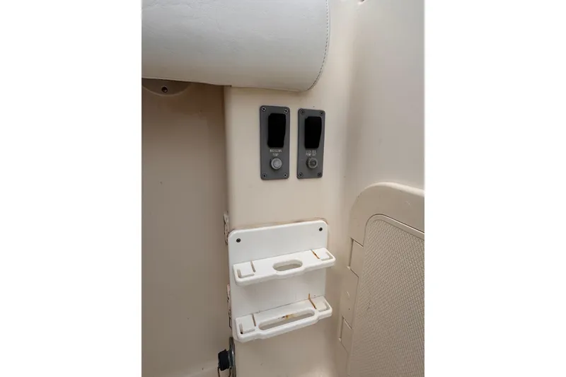 Slide: The Image of 2004 Pursuit 2670 Cuddy Console interior with control panel and storage compartments. - 18