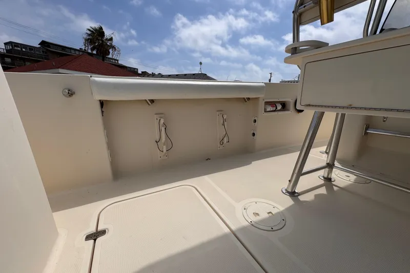 Slide: The Image of 2004 Pursuit 2670 Cuddy Console boat interior with storage and seating area. - 19