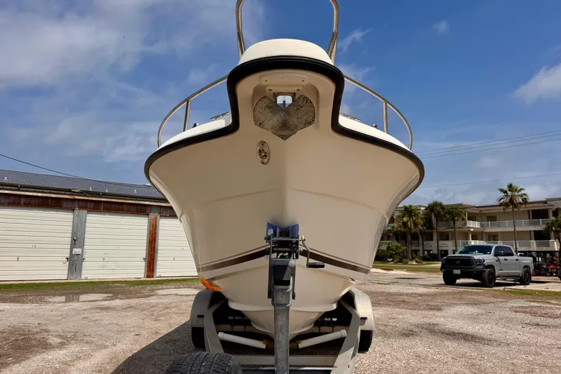 Slide: The Image of 2004 Pursuit 2670 Cuddy Console boat on trailer, parked outdoors under blue sky. - 2