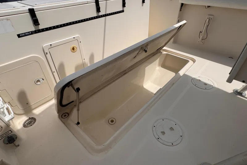 Slide: The Image of Open storage compartment on a 2004 Pursuit 2670 Cuddy Console boat deck. - 20