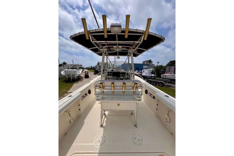 Slide: The Image of 2004 Pursuit 2670 Cuddy Console boat with T-top and rod holders, docked outdoors. - 22