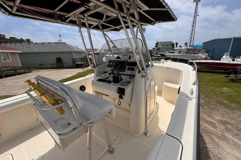 Slide: The Image of 2004 Pursuit 2670 Cuddy Console boat with helm and seating, docked outdoors. - 23