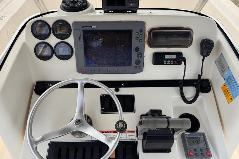 Slide: The Image of 2004 Pursuit 2670 Cuddy Console dashboard with steering wheel, gauges, and navigation equipment. - 26