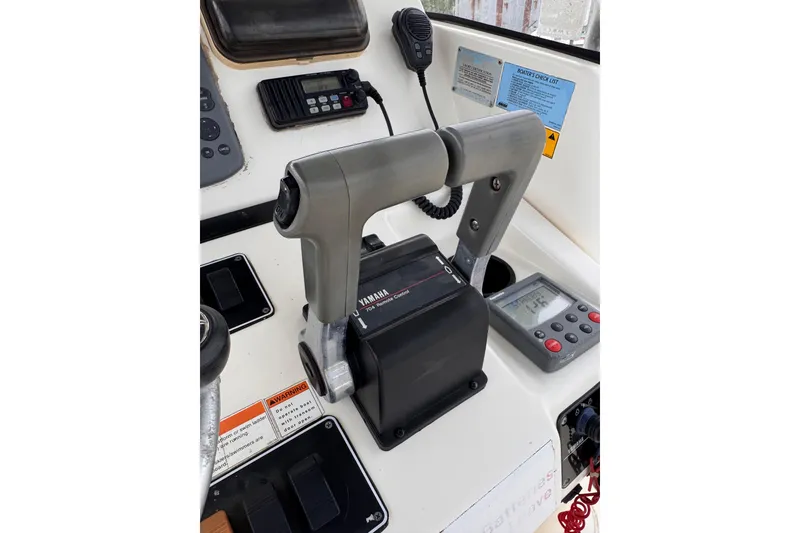 Slide: The Image of Throttle controls on a 2004 Pursuit 2670 Cuddy Console boat dashboard. - 28