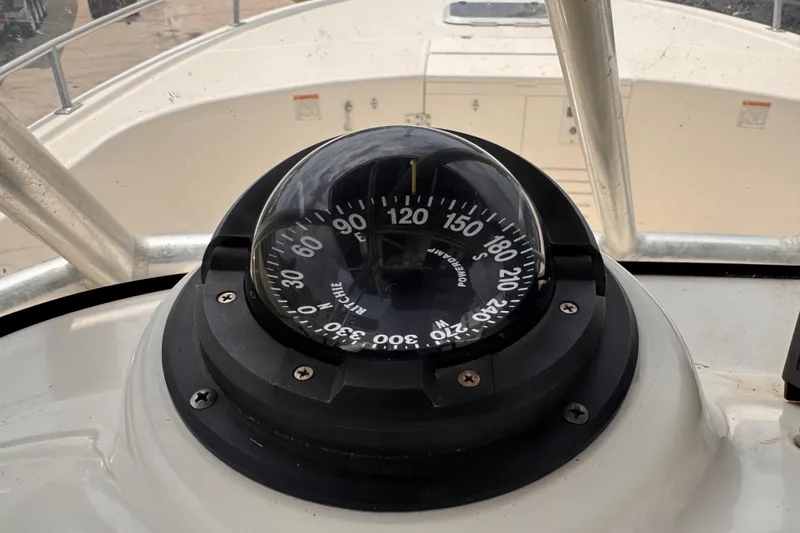 Slide: The Image of Compass on 2004 Pursuit 2670 Cuddy Console boat dashboard, showing navigation directions. - 32