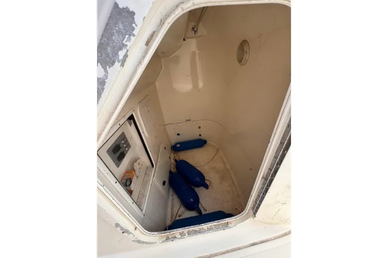 Slide: The Image of 2004 Pursuit 2670 Cuddy Console interior storage with blue fenders and control panel. - 35